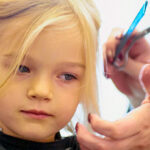 Cute little girl in hairdressing salon. Selective focus